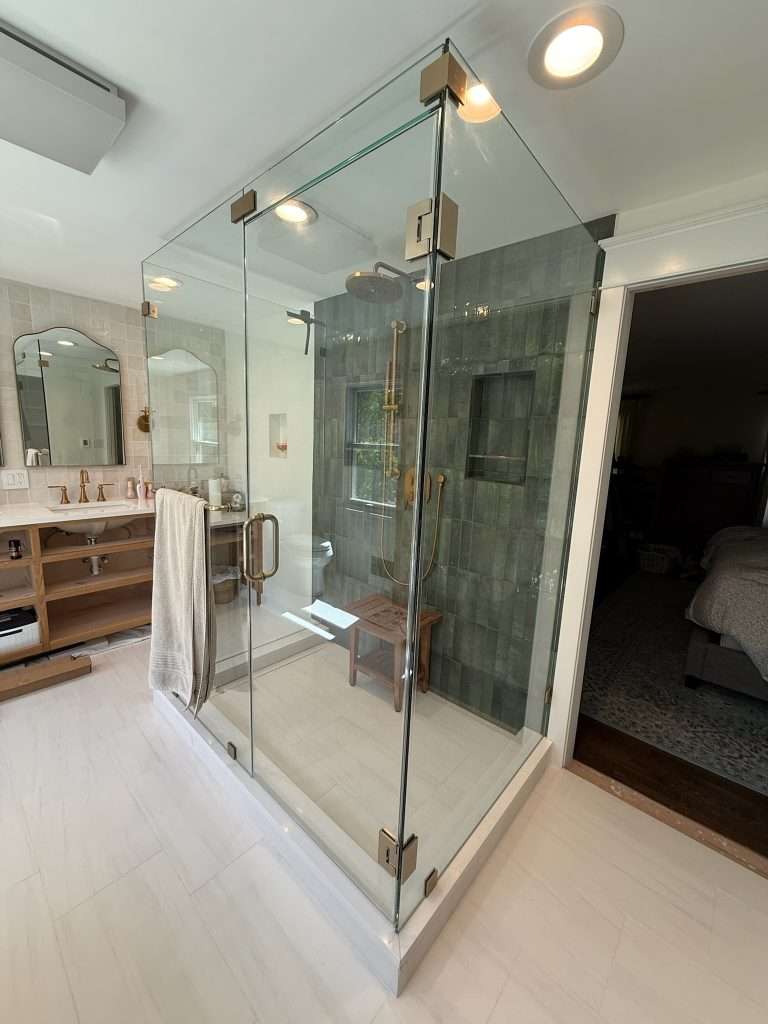 Modern glass shower with green tile accent wall