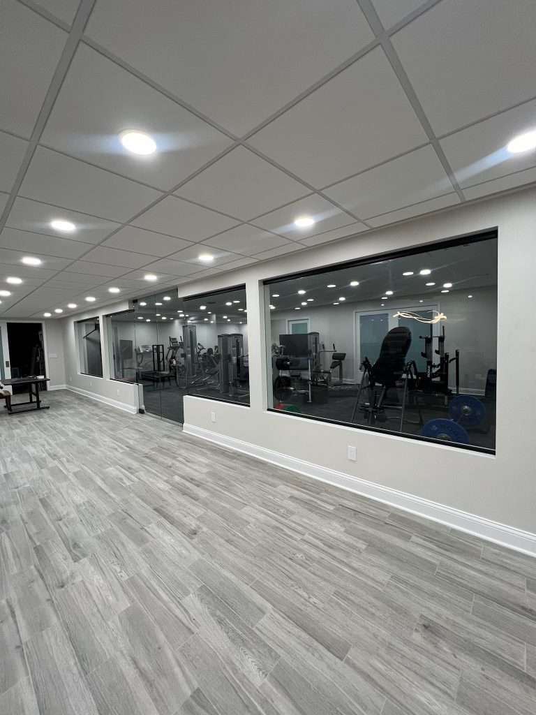 Modern basement hallway with windows into home gym