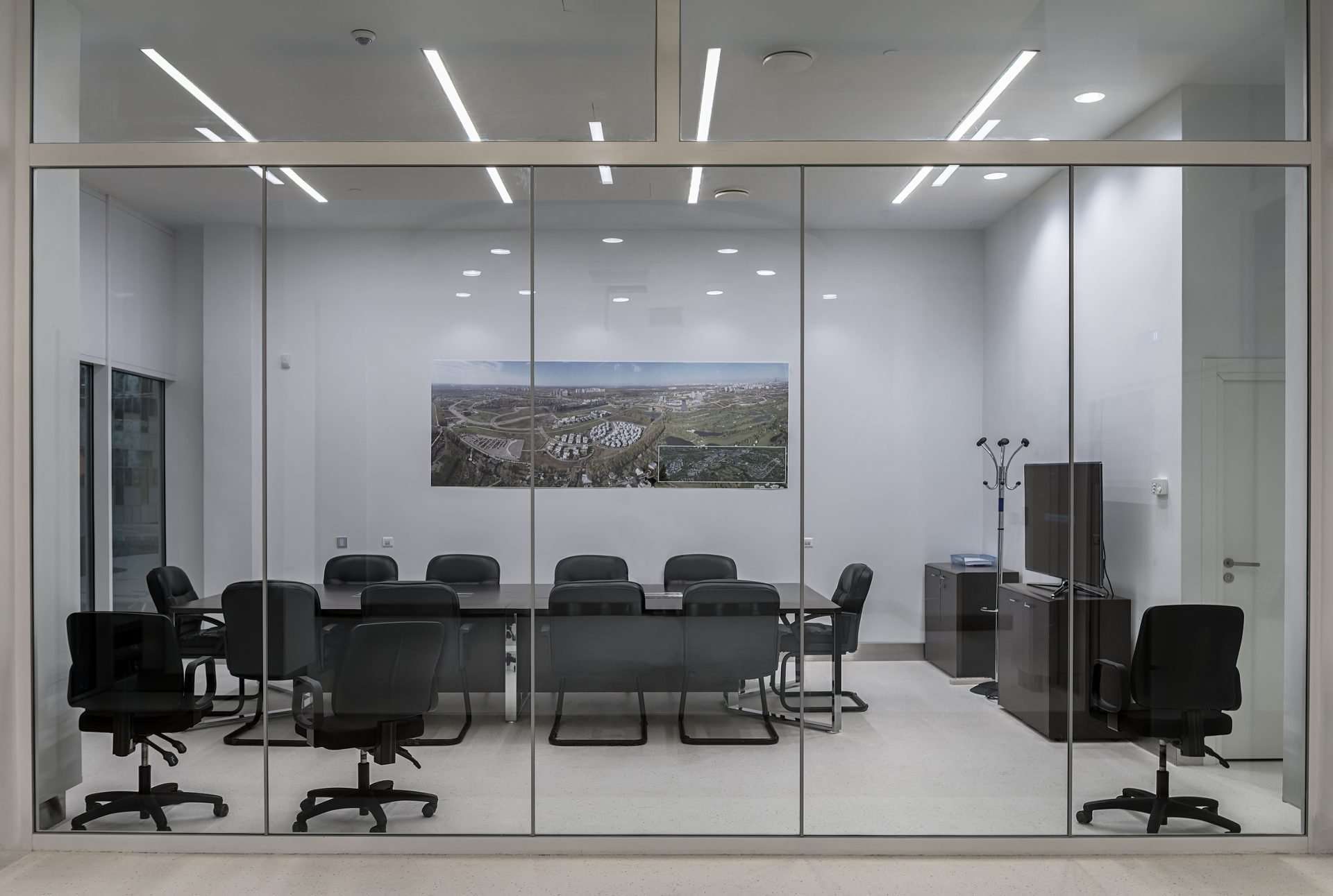 Modern glass-walled conference room with black chairs